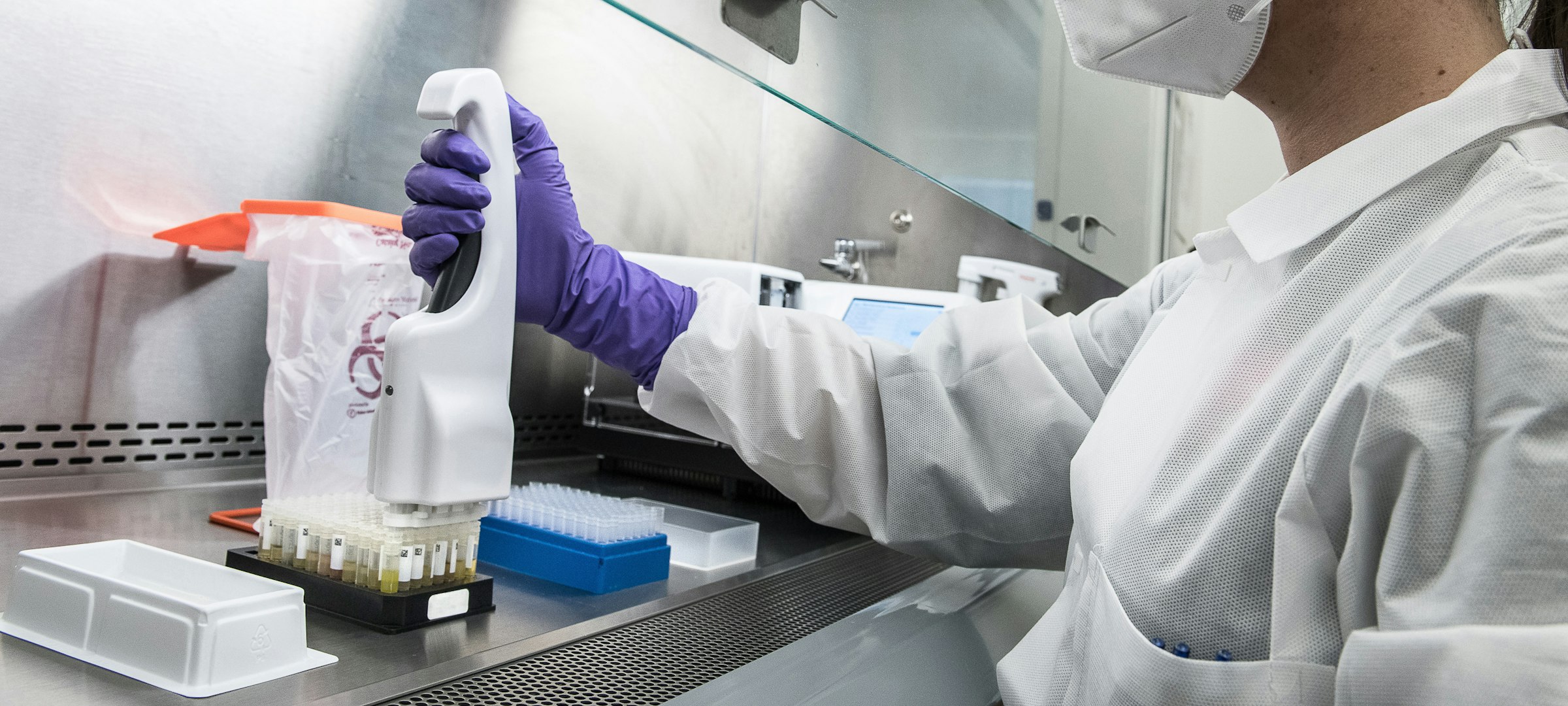 An independent laboratory technician running a colorfastness test on kit fabric samples