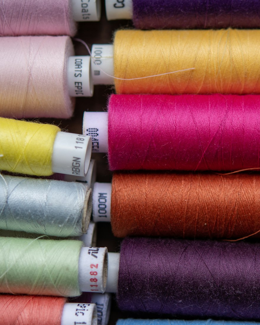 Row of 24-head embroidery machine heads stitching the same chest logo