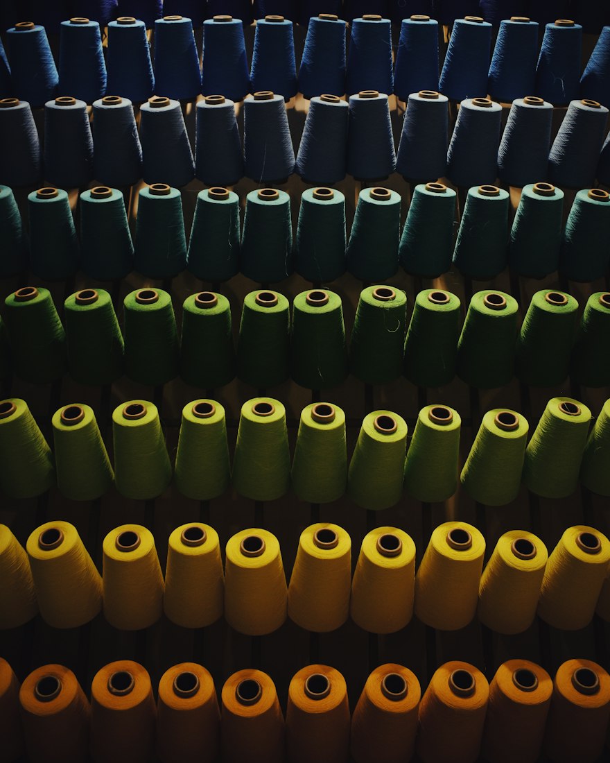 Operator sewing a button placket on a woven work shirt line