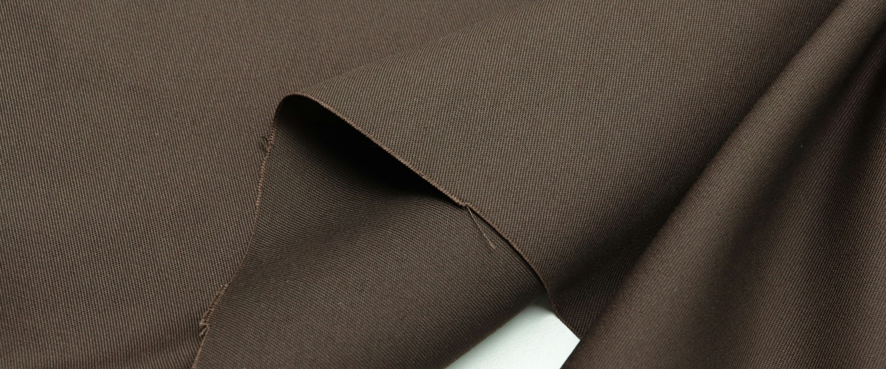 Full-bleed dark brown twill fabric, folded back on itself