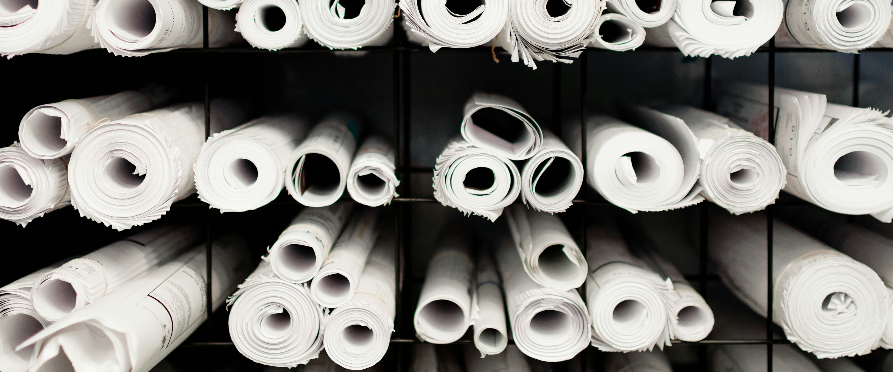 Rolls of jersey fabric racked in an archive, the quiet start of every retail programme