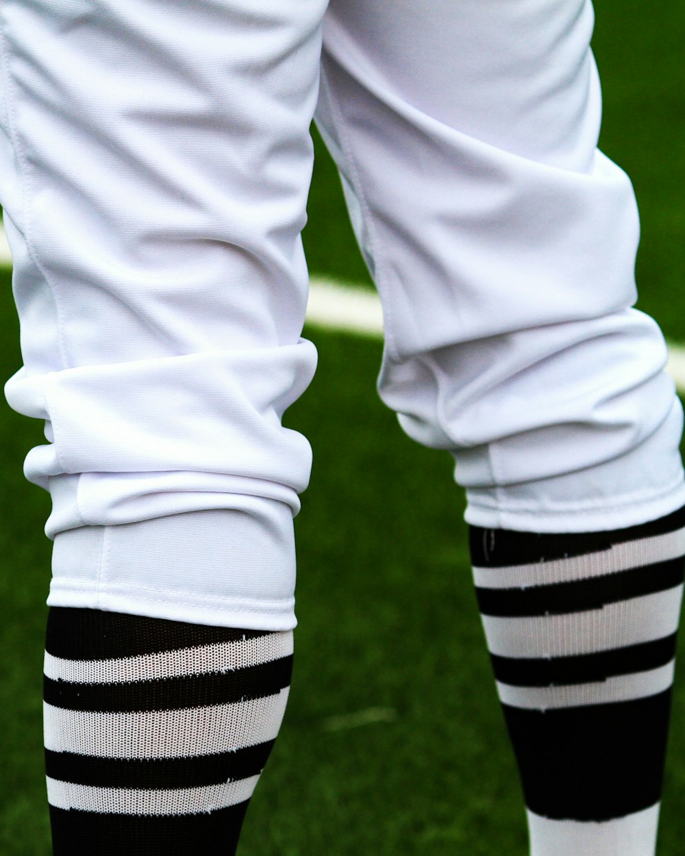 Side profile of a cut-and-sew hockey sock in a red and white fictional team colorway with a two-digit number