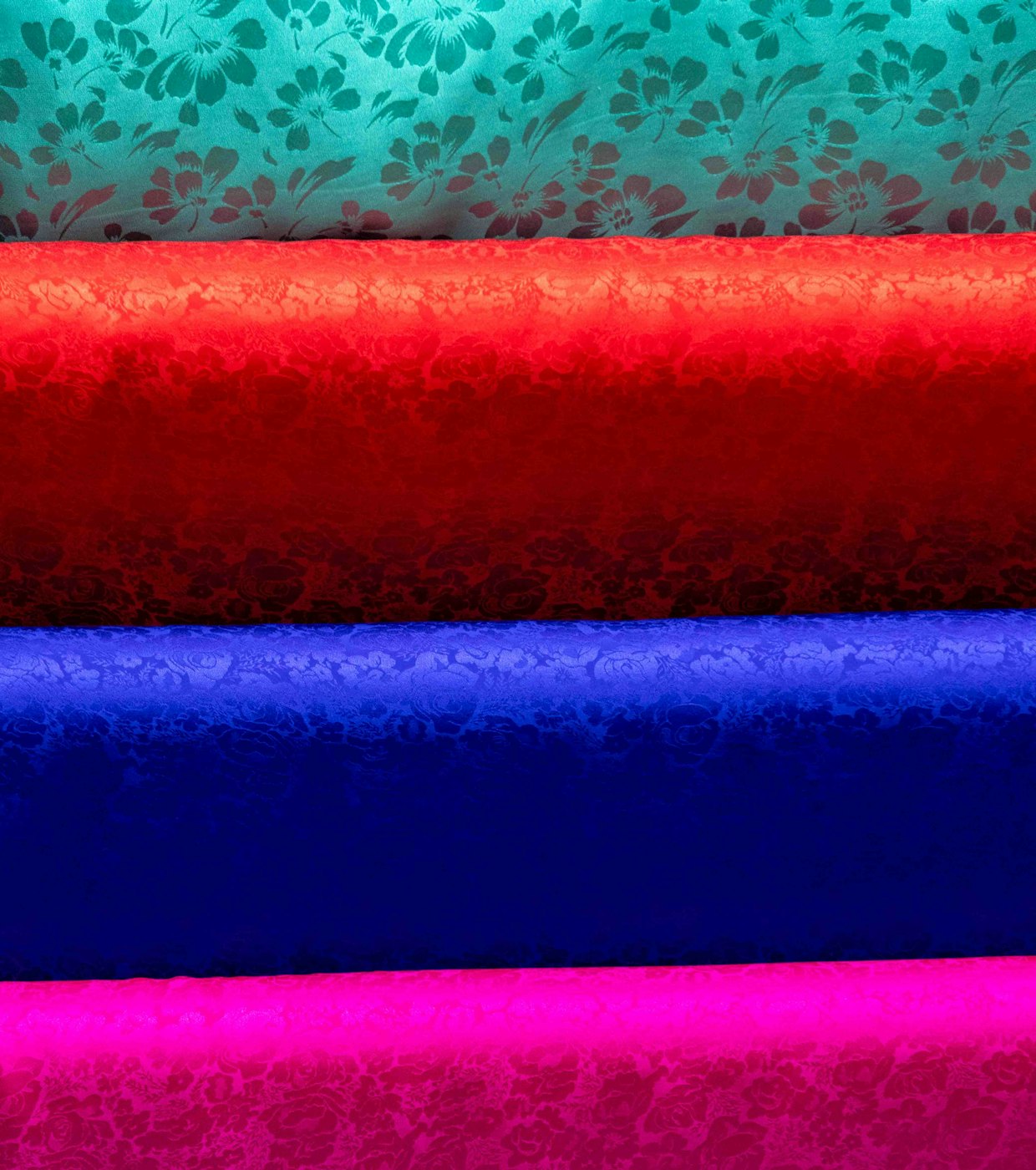 Three fabric swatches in the jersey sock and shell bases laid side by side under the same light, converging on one approved team color