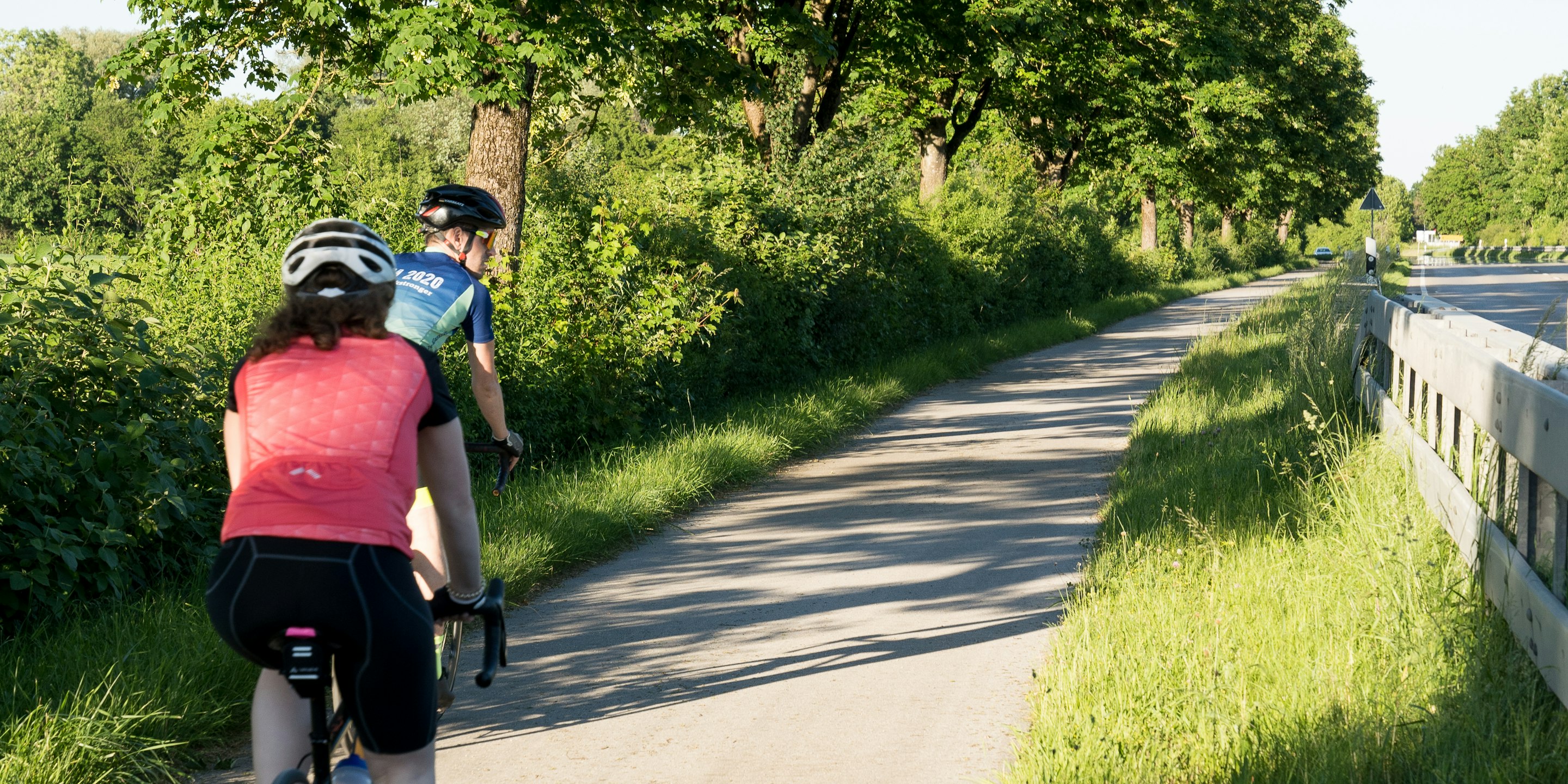 A cyclist riding in an aero-tucked position on an open road