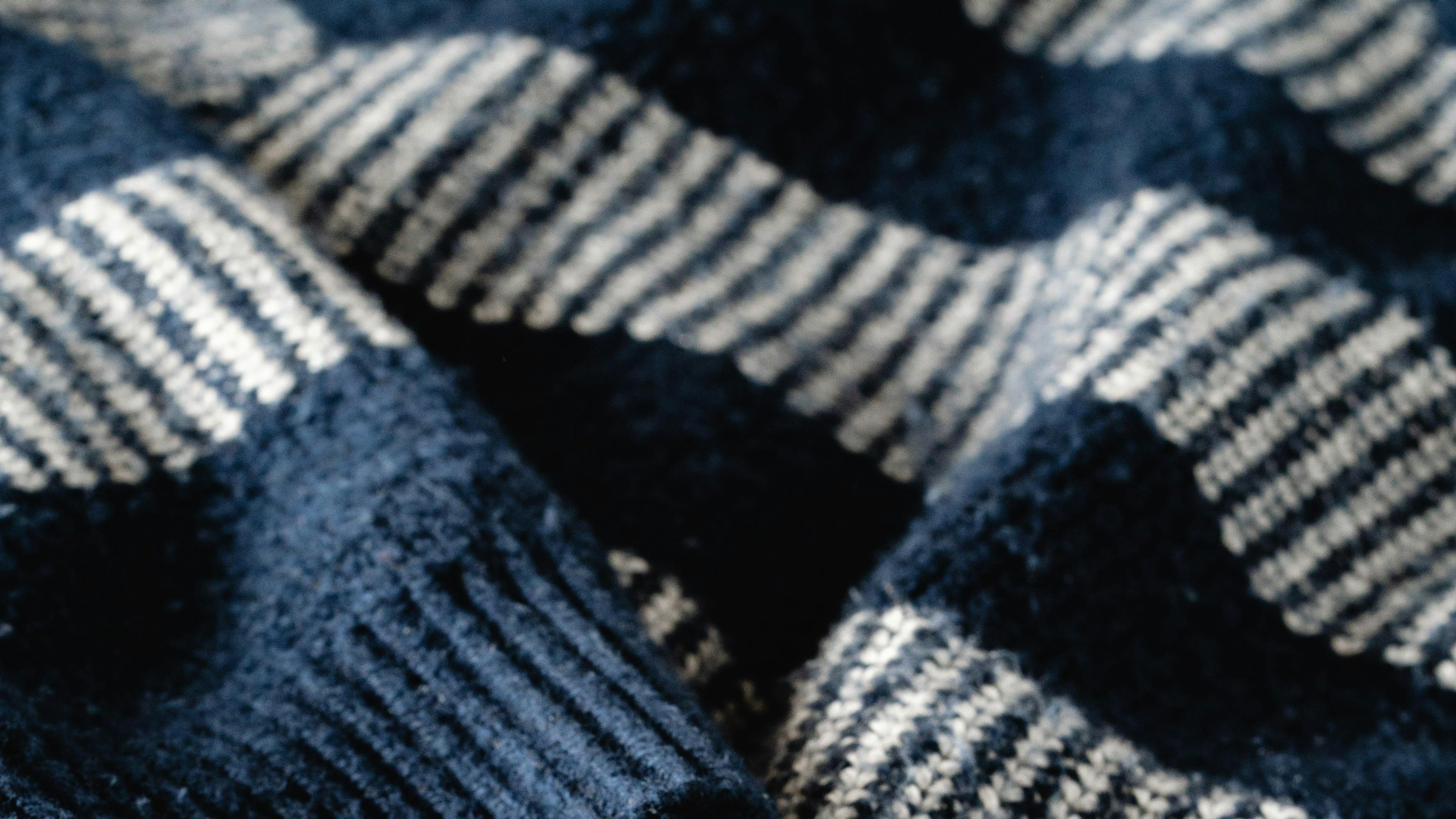 Macro close-up of navy ribbed knit fabric texture