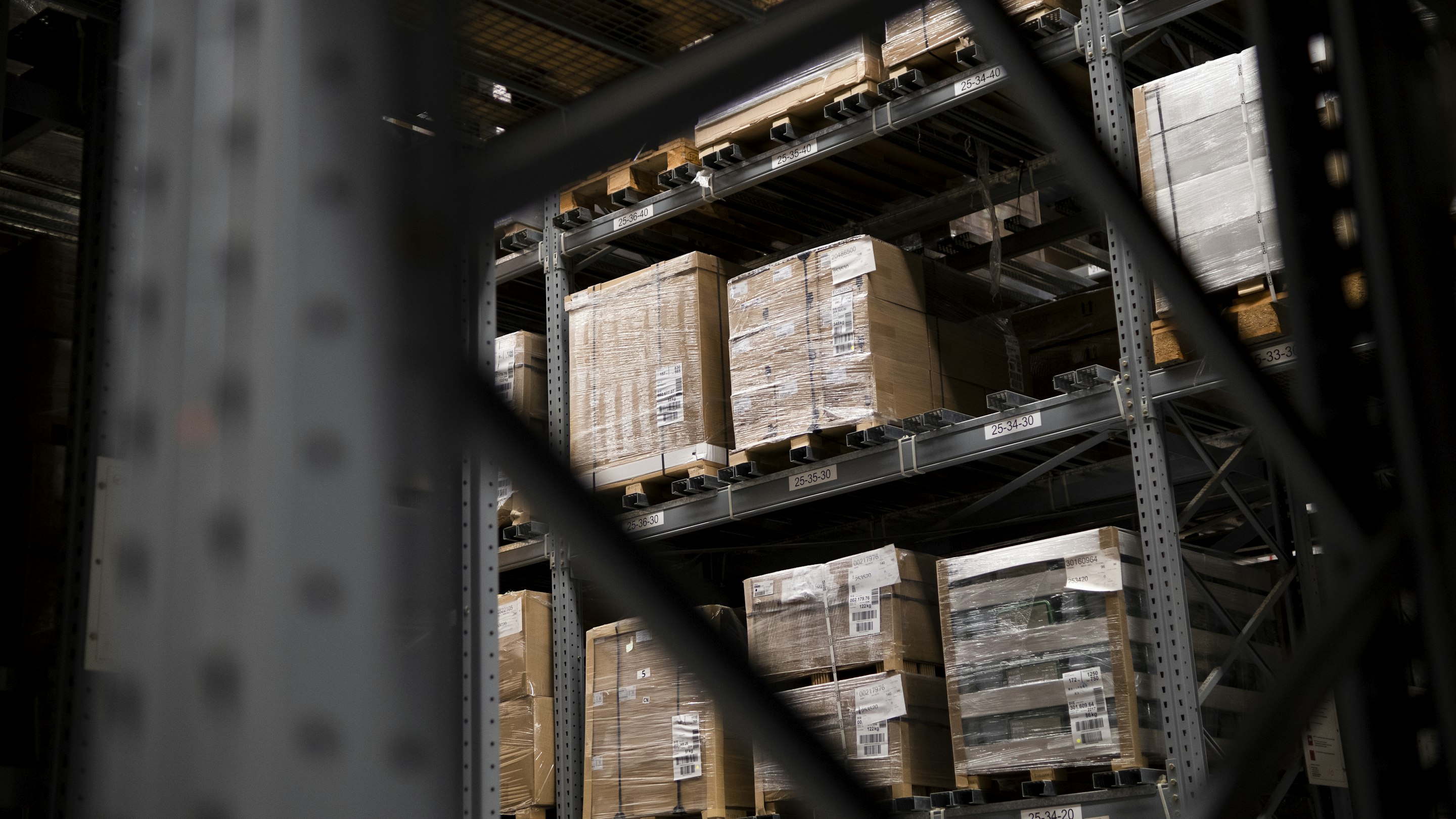 Plastic-wrapped pallets of goods on industrial warehouse racking