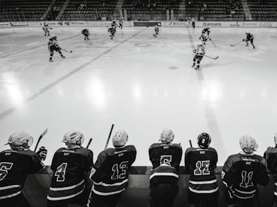 Youth hockey club players lined up on the bench in matching jerseys