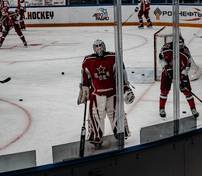 Youth goalie in the crease wearing a goalie cut jersey over pads
