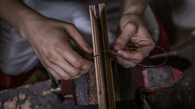 Factory artisan hand-braiding a wig taking 6-10 hours