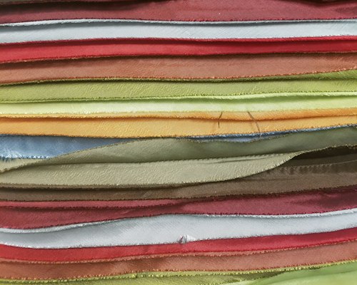 Stack of air knit, double-knit and mesh fabric samples fanned out to compare hand feel