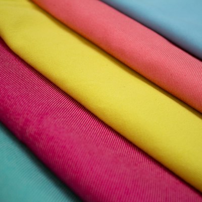 Lightweight air knit polyester practice fabric held up to the light