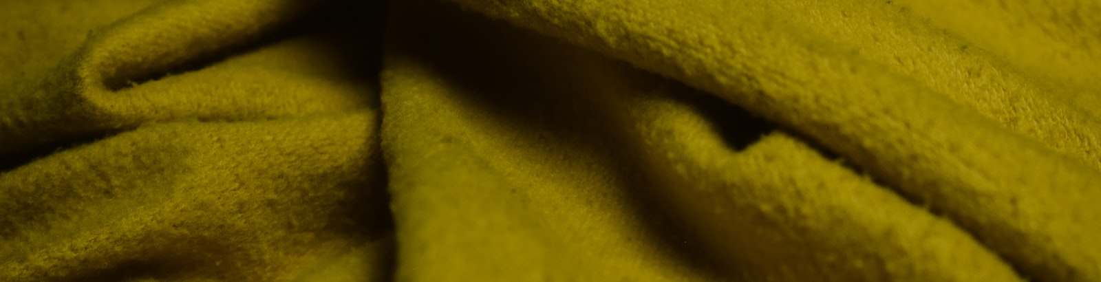 Close macro shot of undecorated knit fabric in the Vegas Gold colorway used for blank hockey socks.