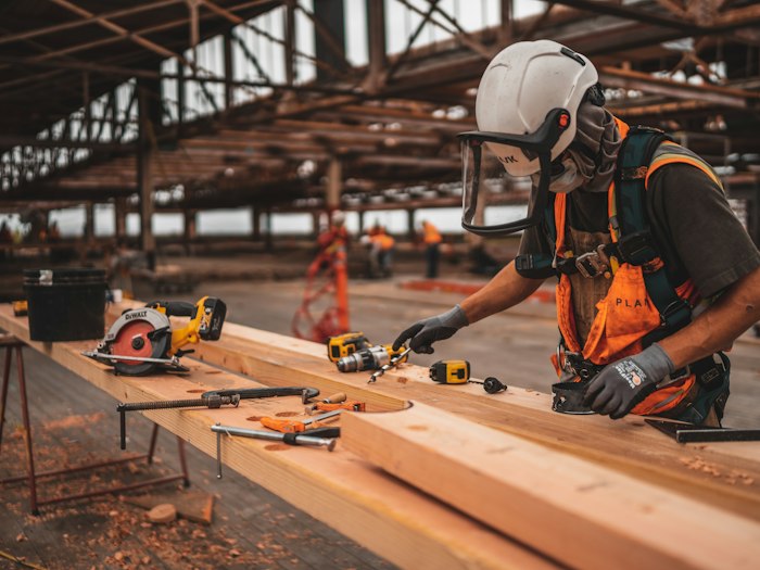 Construction worker in a brown cotton canvas work shirt with a printed back logo