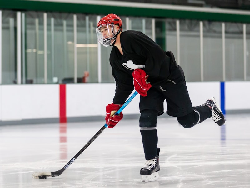 A hockey pant shell in a kelly green and white fictional team colorway worn on the ice over the player's own padded pants