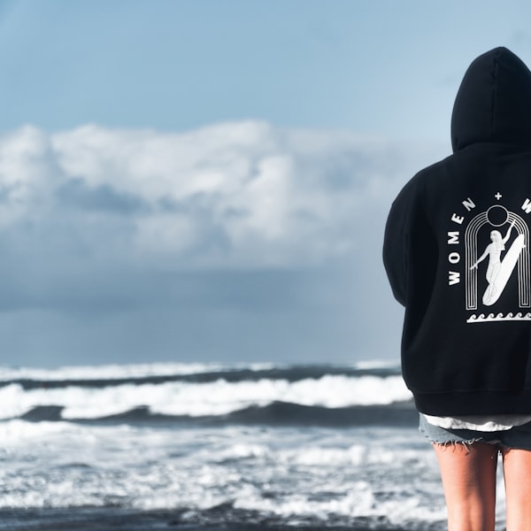 Navy pullover hockey hoodie with an embroidered chest crest on a hanger