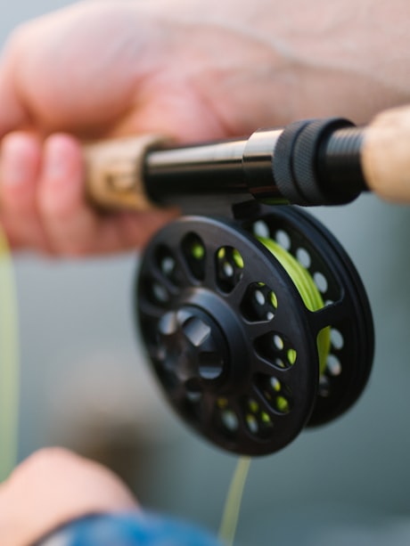Fishing bite alarm manufacturer unit on a rod-pod with roller-wheel line-movement bite detection and wireless receiver, on dark slate