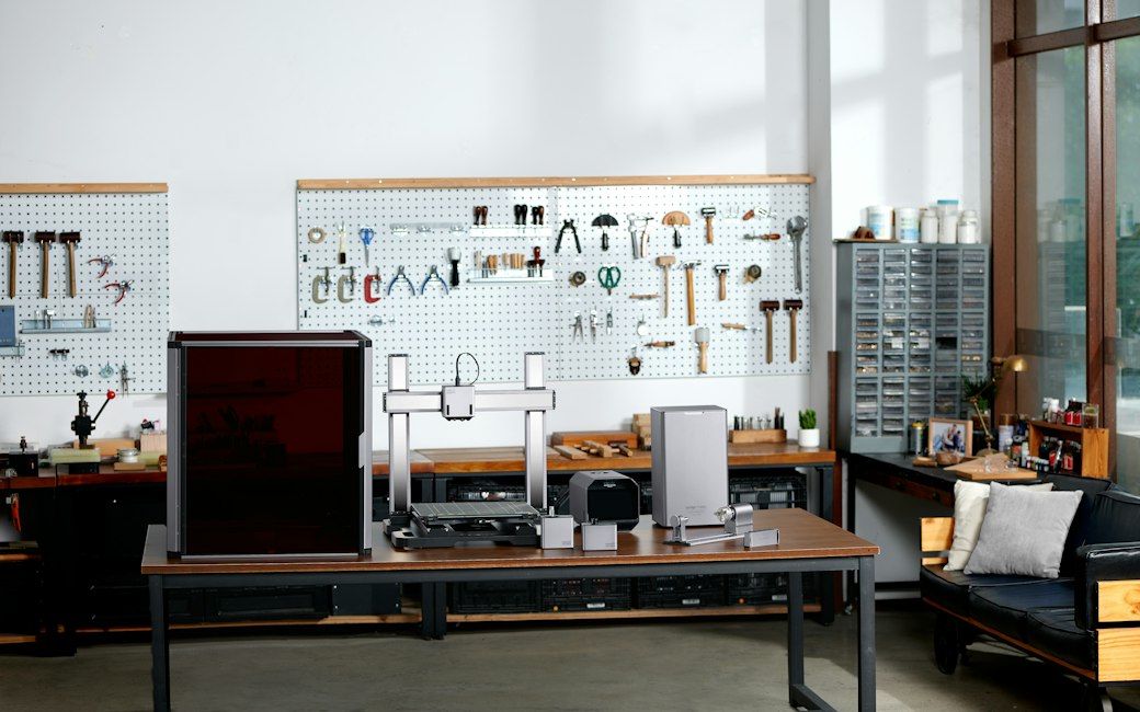 Small embroidery shop with blank tan canvas work shirts stacked beside a single-head machine
