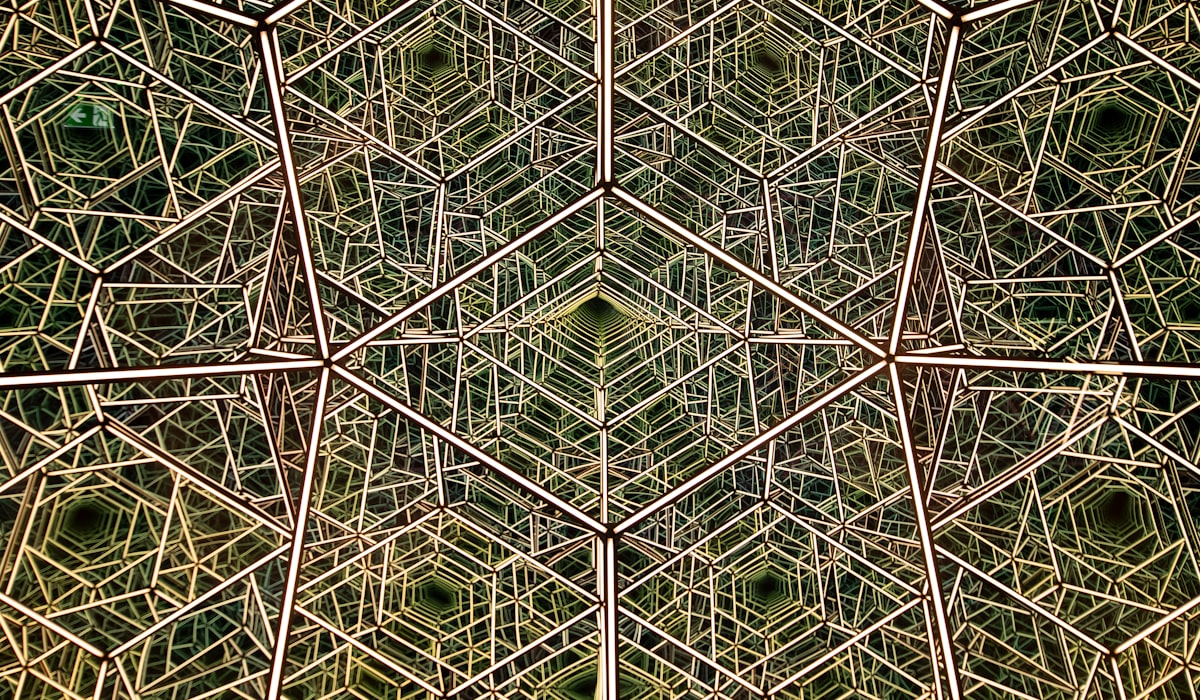 Cross-section of a two-layer print: a masking layer that is opaque when dry and clear when wet, the permanent artwork layer beneath it, and the base cloth, with a dry to wet state arrow and a stretch arrow marked must stretch and recover.