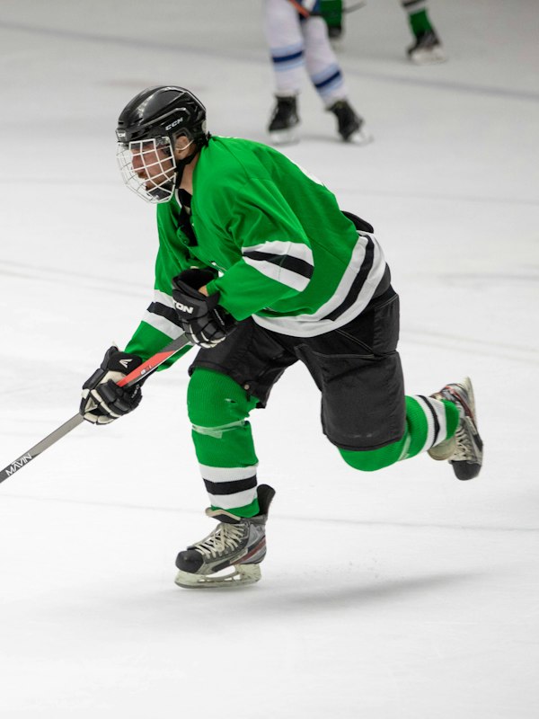 Hockey player wearing shoulder pads and elbow pads under a jersey, showing the space equipment takes