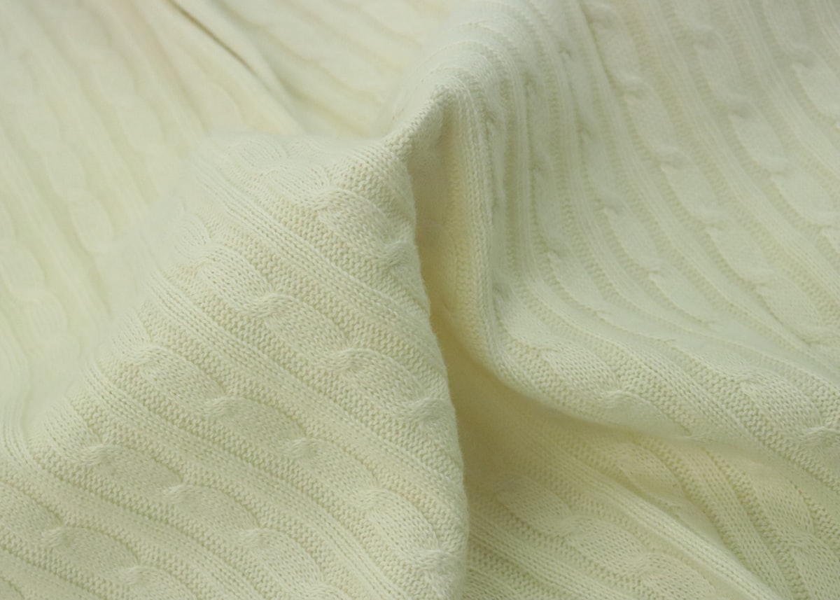 Close macro shot of double-knit polyester fabric, tighter and denser weave than the air knit base.