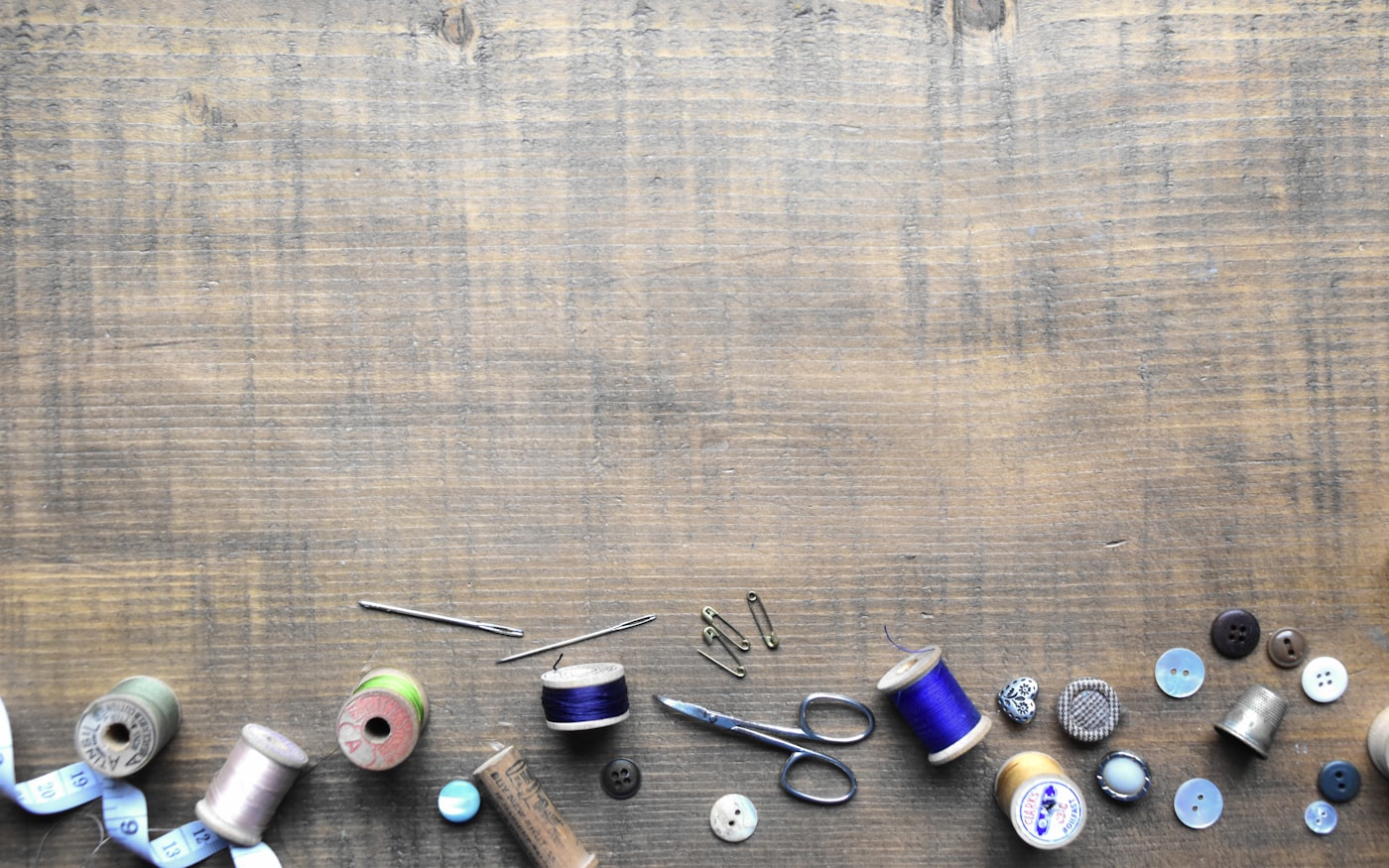 Sewing tools — scissors, thread, needles — on a workshop table
