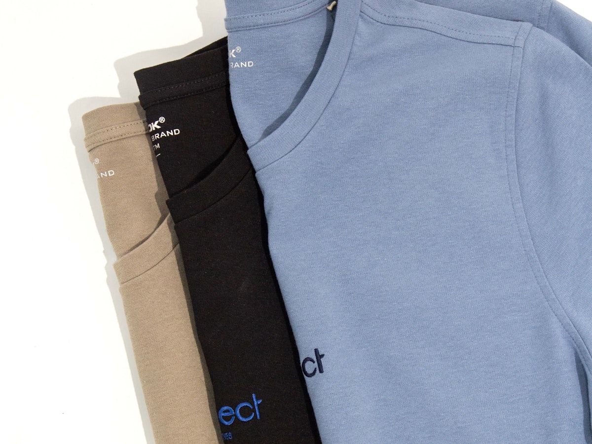 Finished blank garments sorted by color — a standing-color order is still cut and sewn to order, then packed by color and size