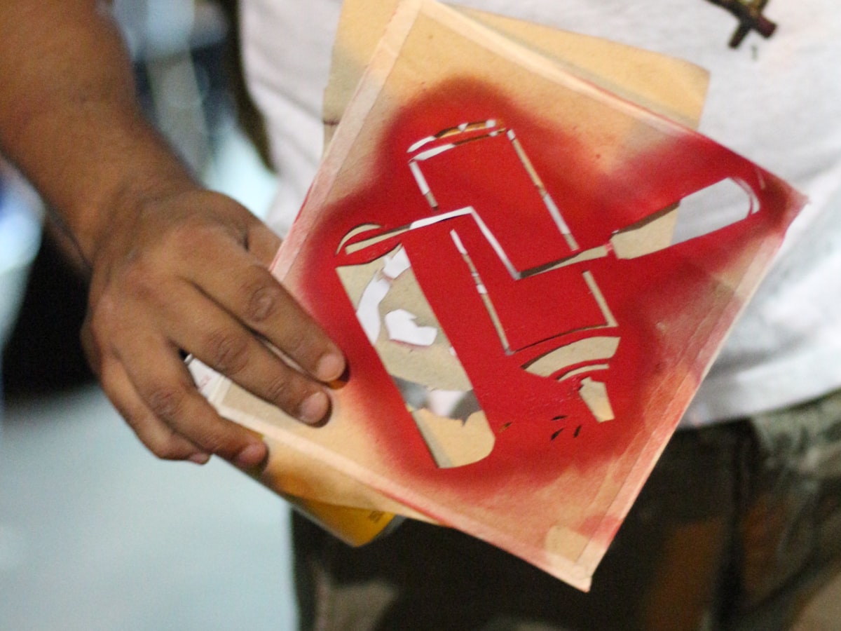 A print stencil being handled — printed routes lay color as a flat image, and sublimation carries it inside the fiber