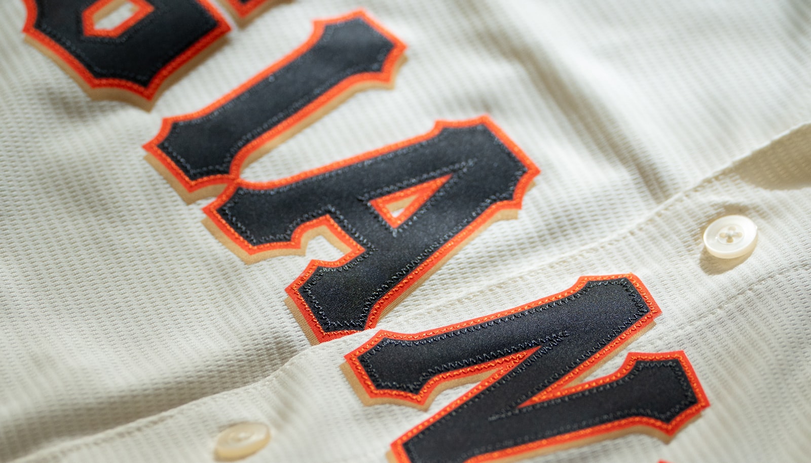A blank hockey jersey and a plain fabric swatch card beside a clean inquiry workspace in a dark closing band.