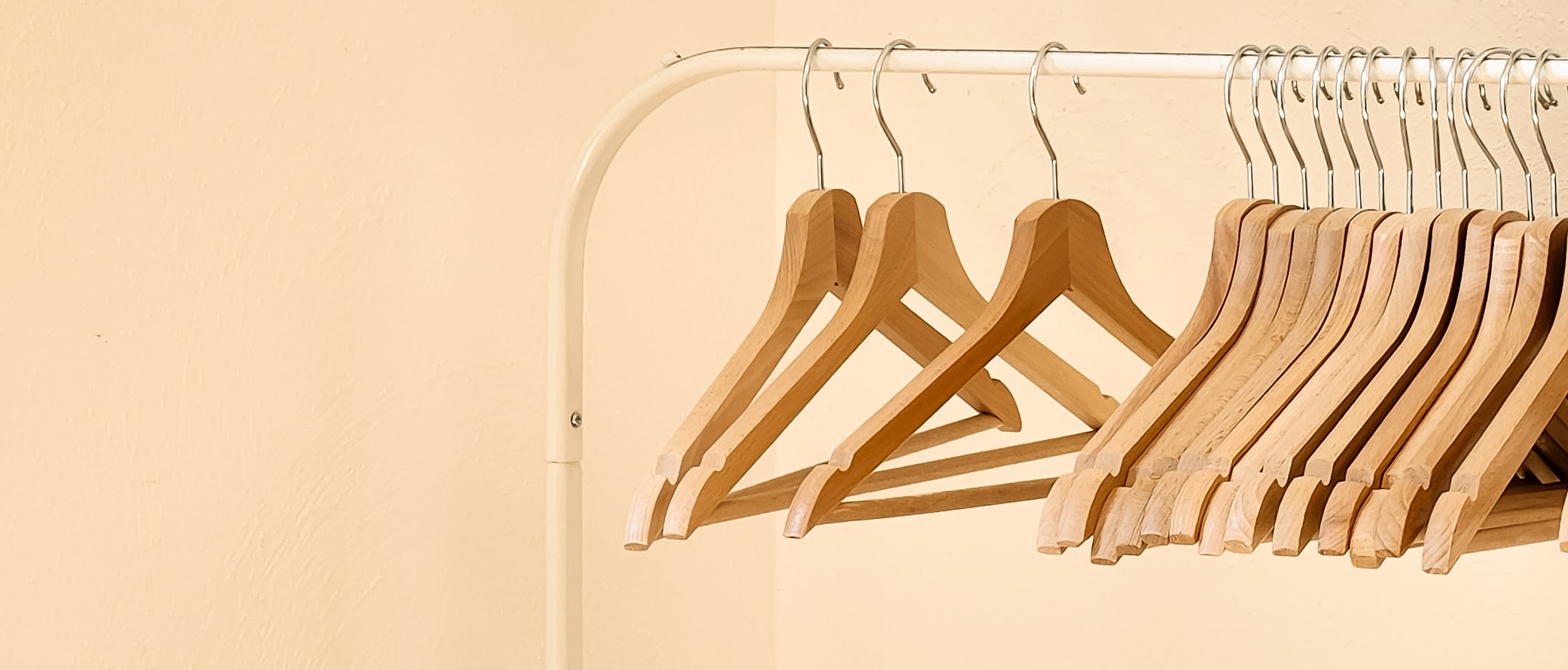 A rail of garments hanging in size sequence — one continuous run from the smallest label to the largest