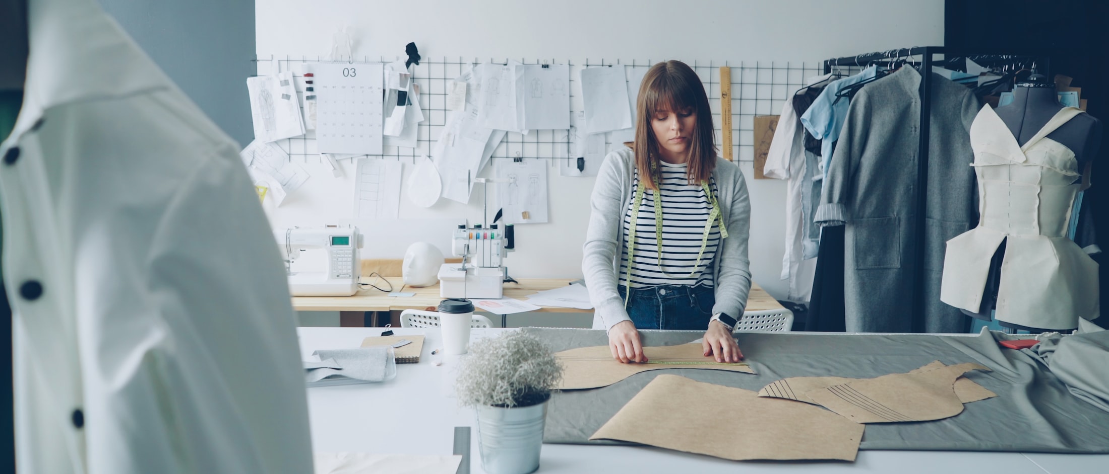 Measuring a received garment against the published production tolerance — the receiving check any buyer can run